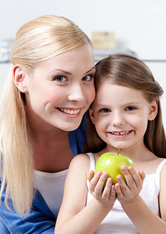 Photo of mother and a daughter holding a apple